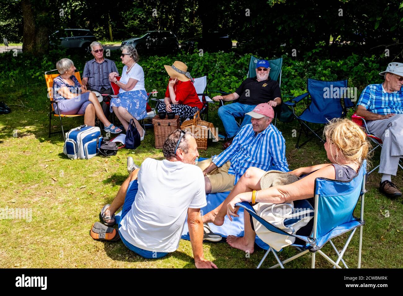 Einheimische sitzen mit EINEM Picknick im Nutley Fete, Nutley, East Sussex, Großbritannien. Stockfoto