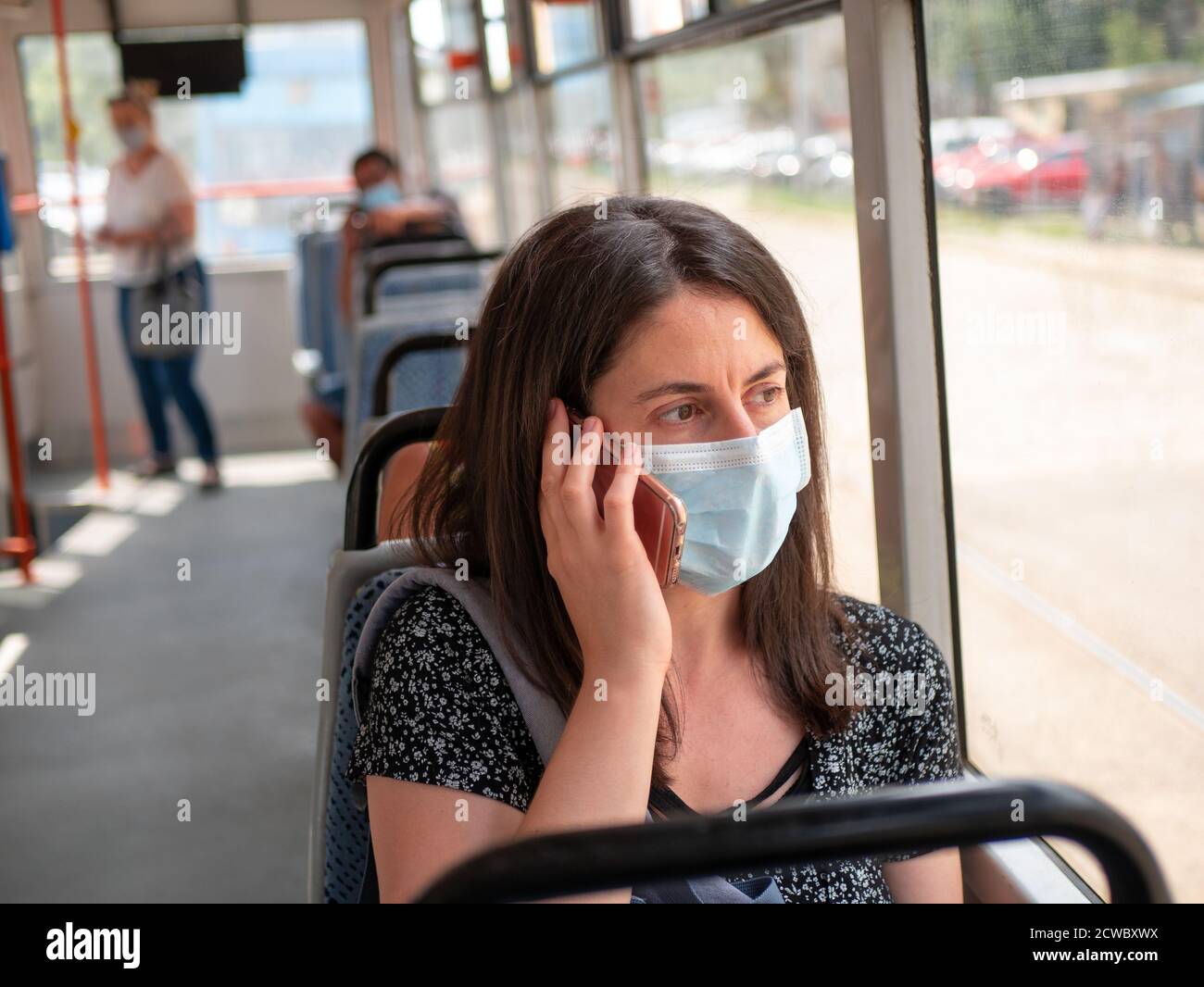 Frau, die während der Coronavirus-Pandemie Covid 19 in Sofia, Bulgarien, mit Gesichtsmaske im Bus in öffentlichen Verkehrsmitteln unterwegs war Stockfoto
