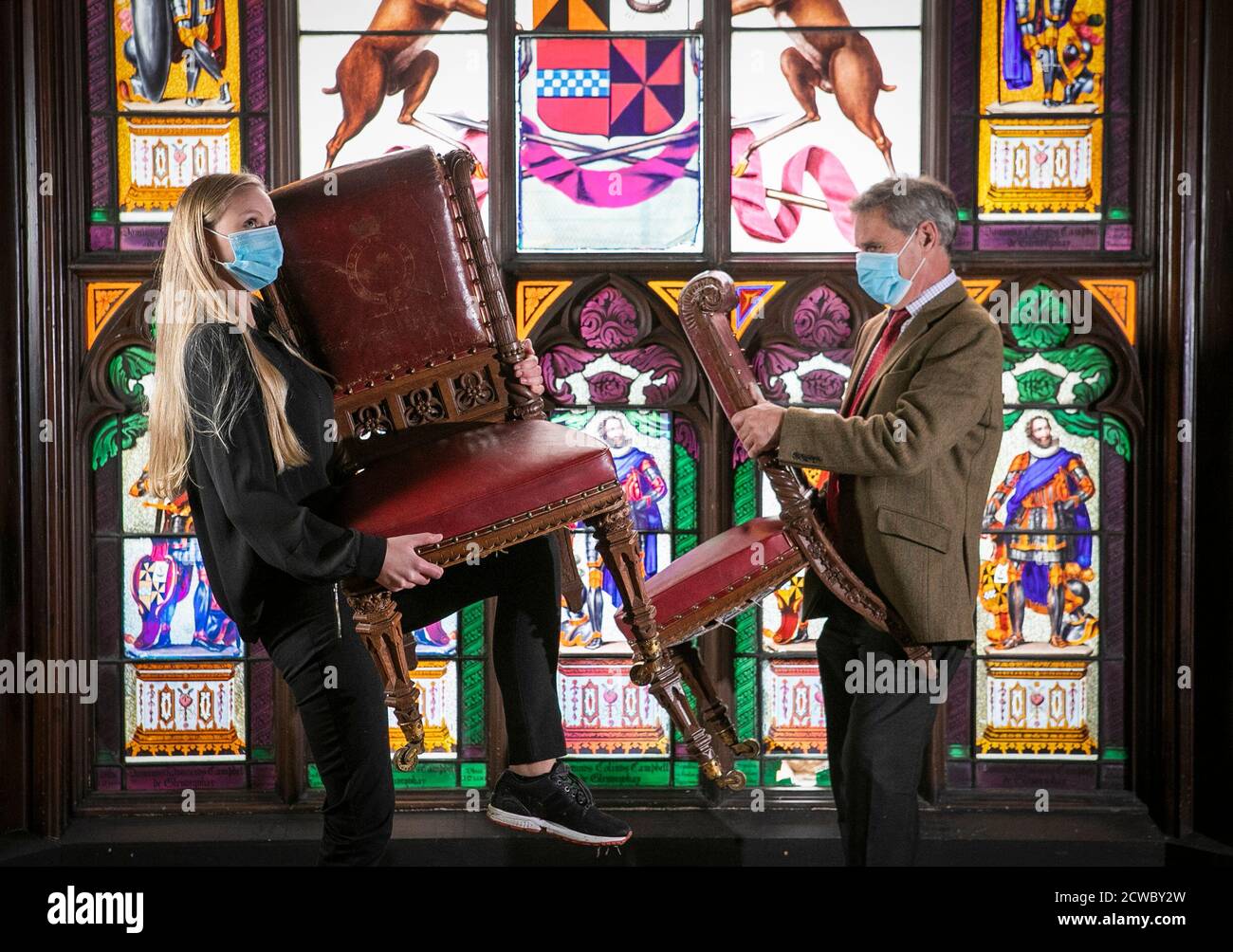 Romey Clark (links) und Charles Graham-Campbell aus Bonhams halten ein Paar von William IV geschnitzten Eichenstühlen im Speisesaal von Taymouth Castle, Kenmore, Perthshire. Die Stühle sind Teil eines Sets von vierzehn, die für die Auktion gehen, mit einer Schätzung von GBP 8,000-12,000, bei der jährlichen schottischen Verkauf in Bonhams Edinburgh am 14. Oktober. Stockfoto