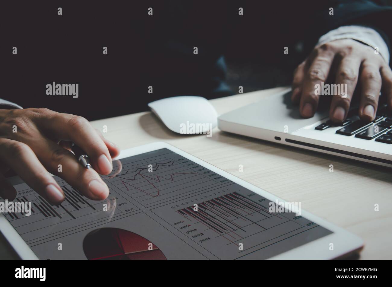 Geschäftsmann, der Grafiken und Diagramme analysiert, berichtet über Gewinn- und Wachstumsstatistiken in Tablets. Stockfoto