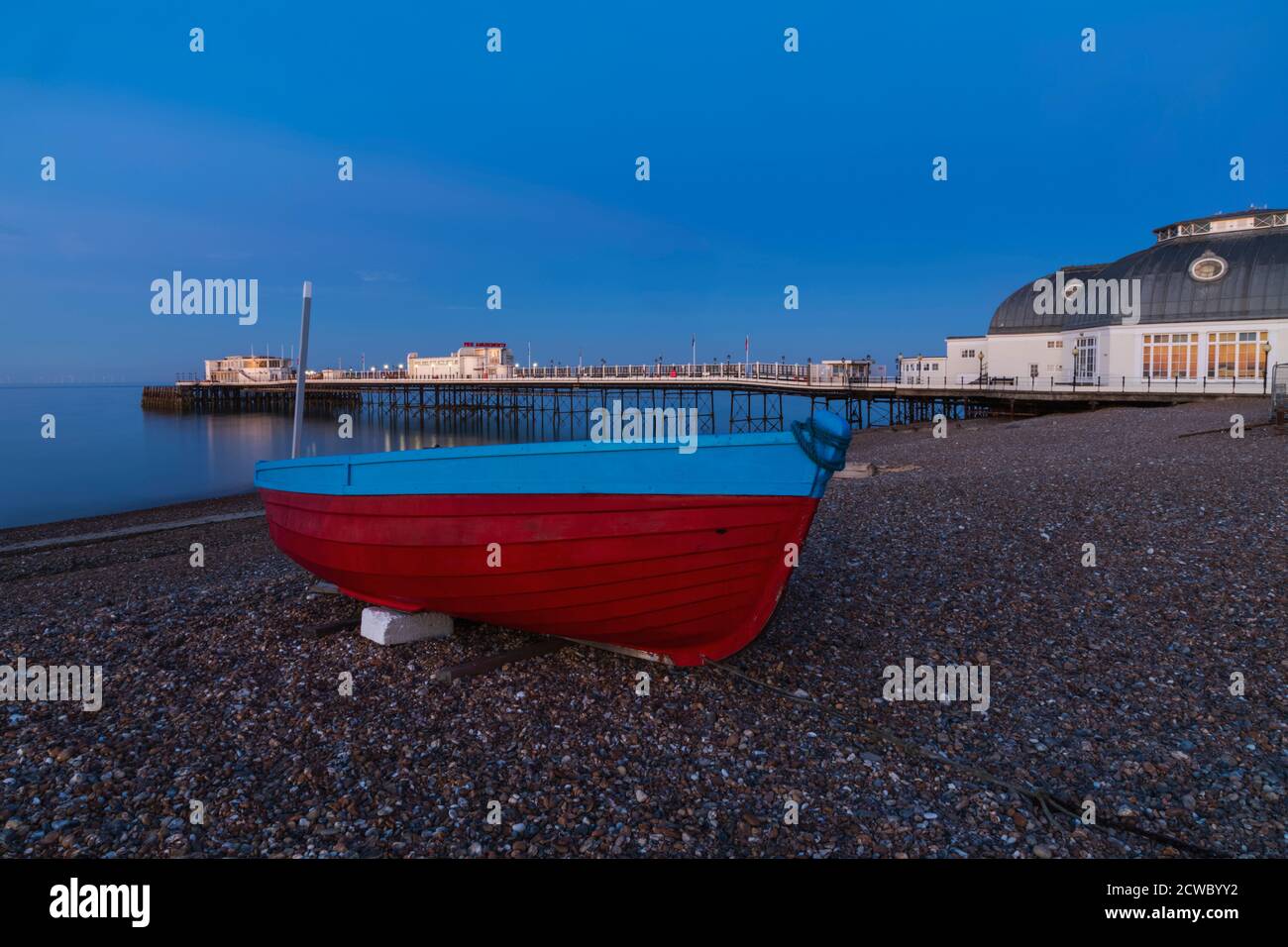 England, West Sussex, Worthing, Worthing Beach und Fischerboot mit Pier Stockfoto