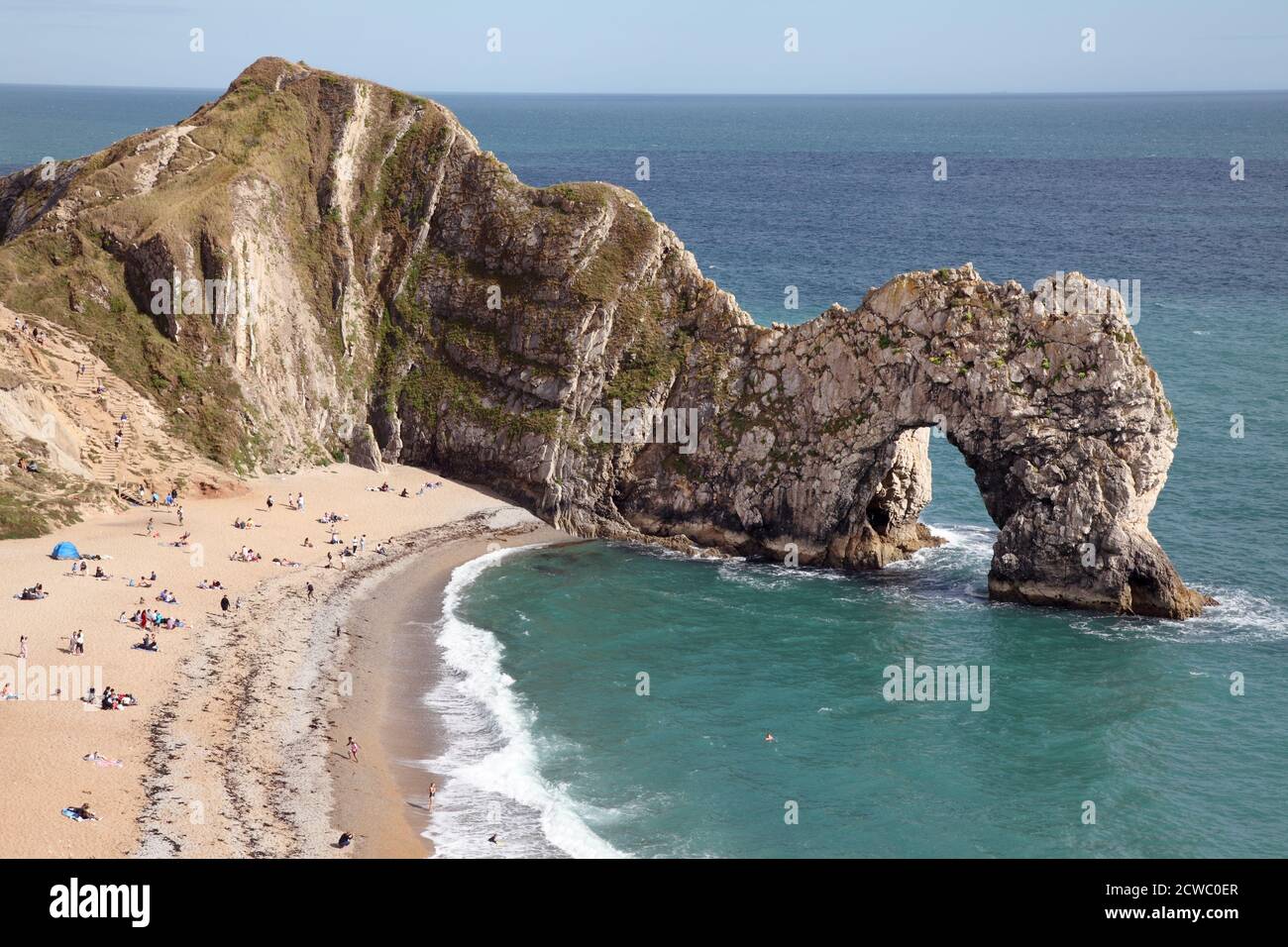 Durdle Door oder Dor Klippen und Felsen Meeresbogen. Teil des Lulworth Estate an der Dorset Jurassic Coast. Mit Leuten am Strand. Stockfoto