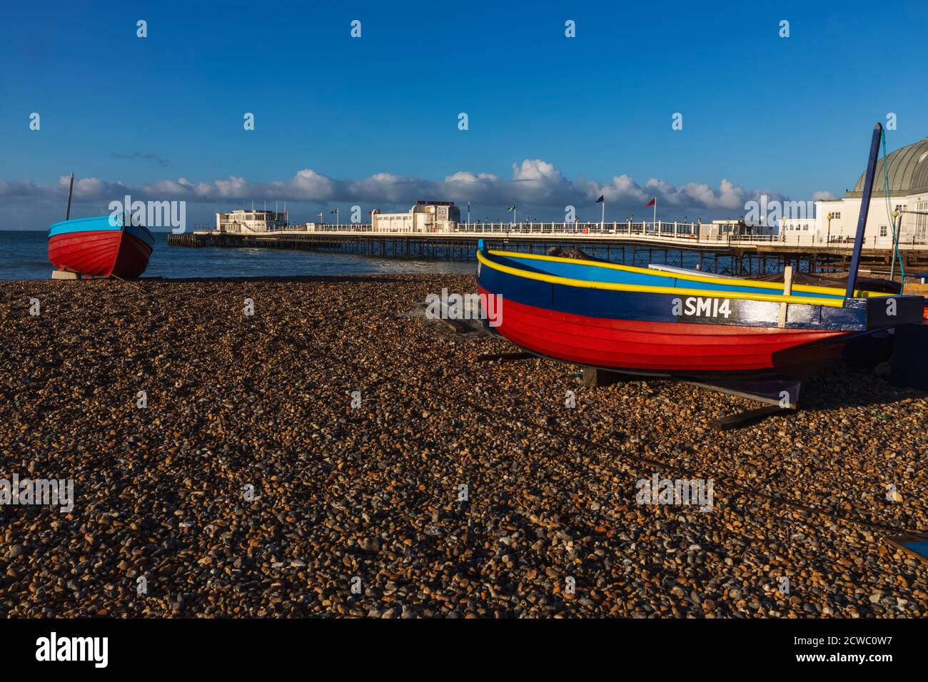 England, West Sussex, Worthing, Worthing Beach und Fischerboot mit Pier Stockfoto