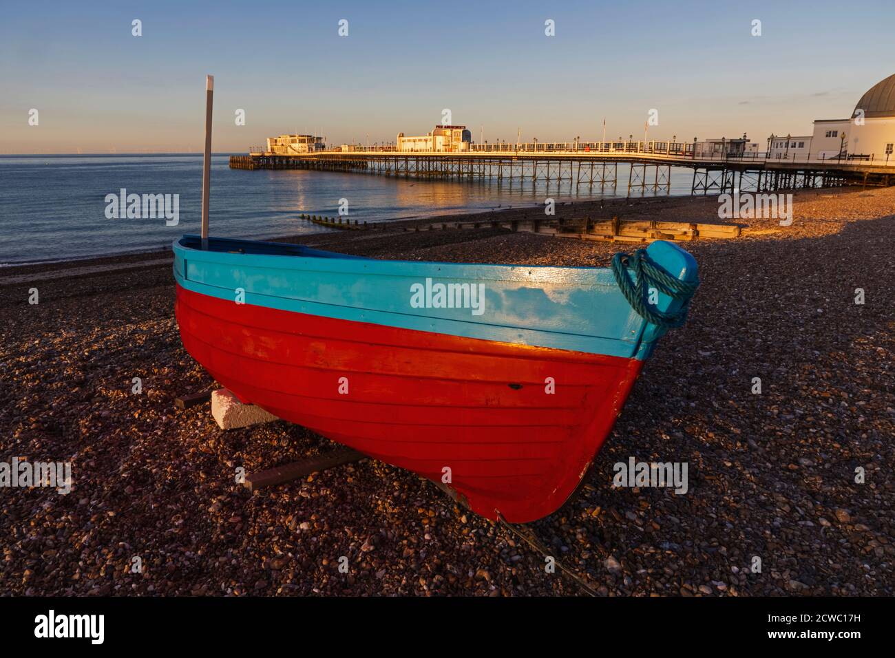 England, West Sussex, Worthing, Worthing Beach und Fischerboot mit Pier Stockfoto