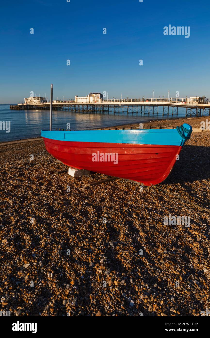 England, West Sussex, Worthing, Worthing Beach und Fischerboot mit Pier Stockfoto