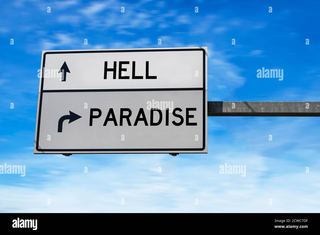 Weißes Straßenschild mit Worten Hölle und Paradies vor blauem Himmel Hintergrund. Stockfoto