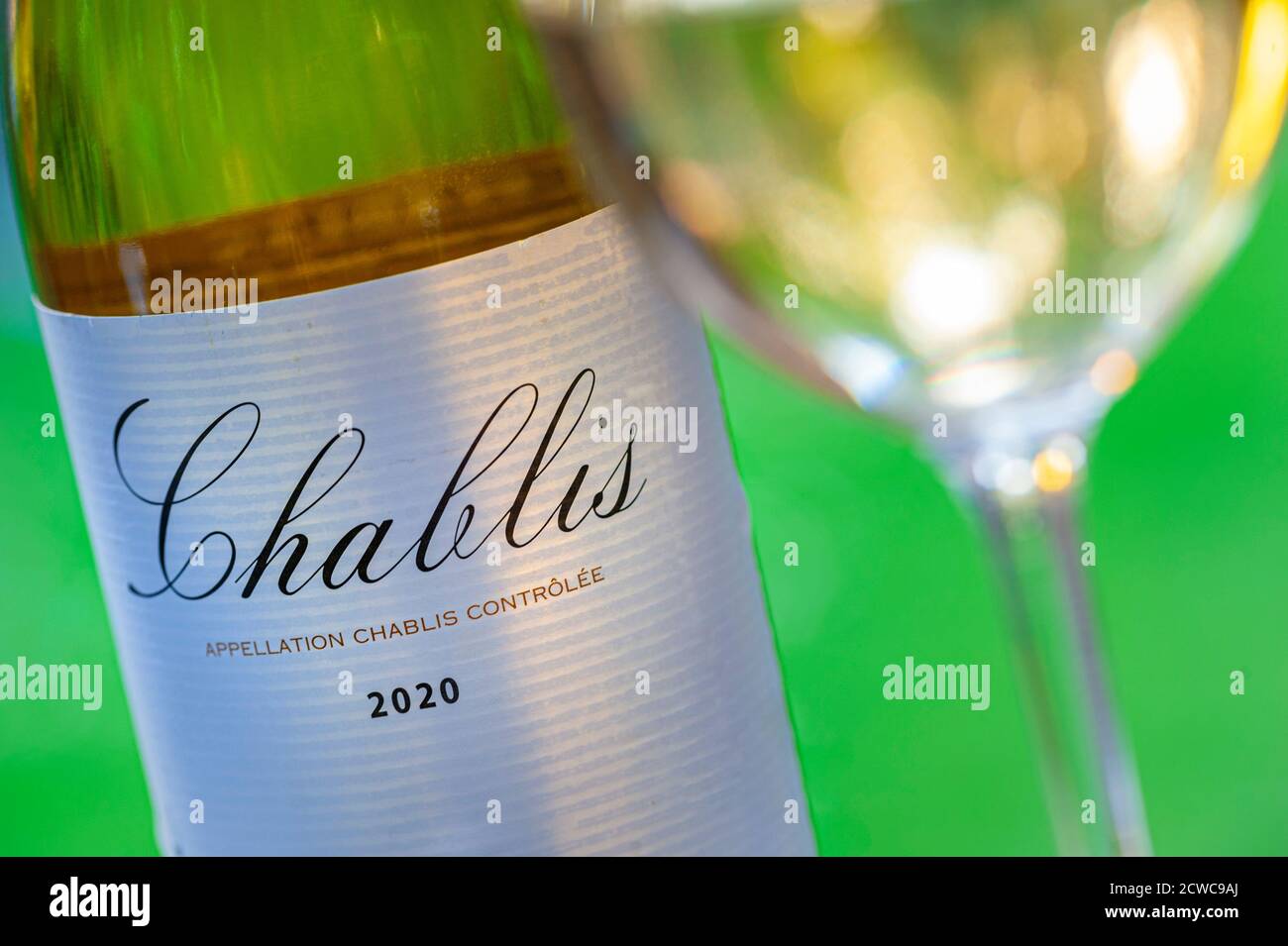 Chablis Glass und 2020 Chablis Flaschenetikett auf der Terrasse Tabelle am späten Nachmittag Sonnenschein Chablis Frankreich Stockfoto