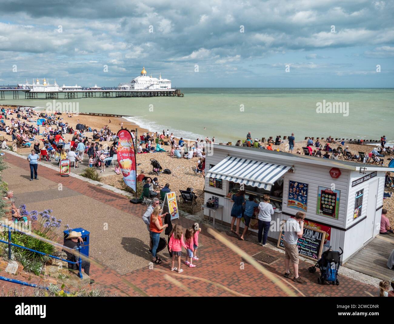 Eastbourne Seafront, England. Eine geschäftige Strandszene auf dem Höhepunkt des englischen Sommers mit Touristen, die das warme Wetter an der britischen Südküste genießen. Stockfoto