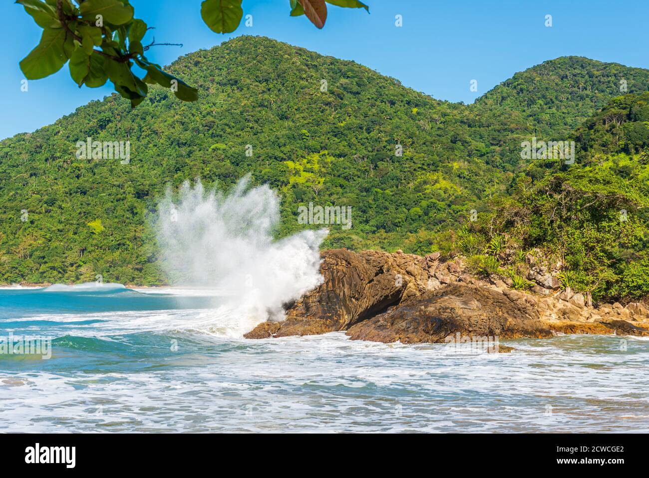Weißer Wellenschaumstoff, der am wilden Strand gegen die Felsen krachte In Brasilien Stockfoto