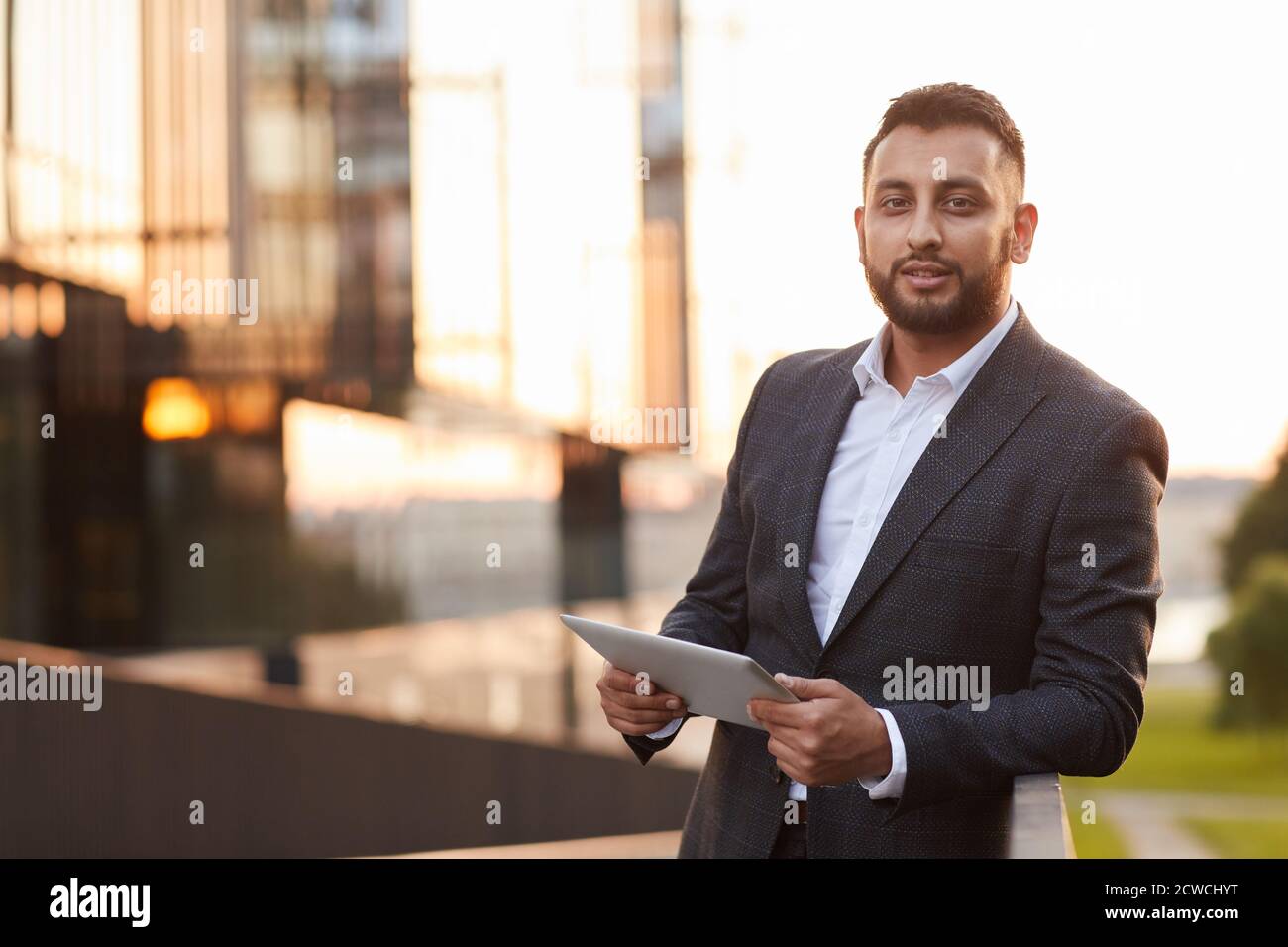 Porträt einer jungen Geschäftsfrau in formellen Anzug Blick auf die Kamera Während der Verwendung von digitalen Tablet in der Stadt Stockfoto