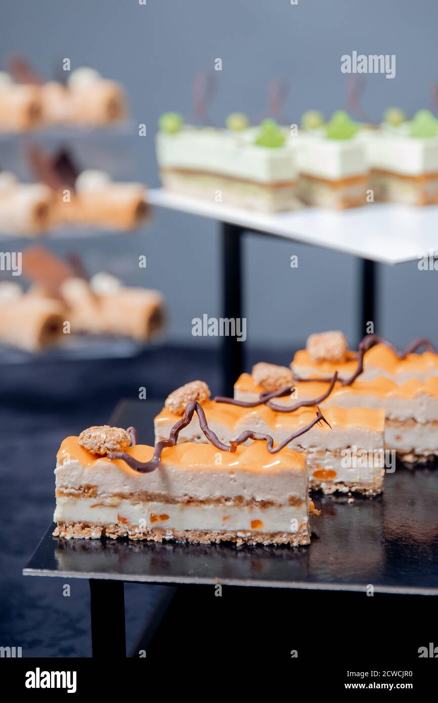 Süßer Desserttisch für Catering und Hochzeiten, Schokoladenkuchen mit Mango und Buttercreme Stockfoto