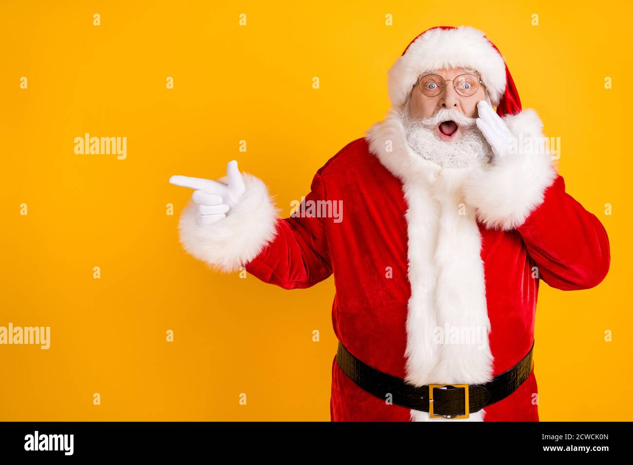 Foto staunte Fett santa claus Point Finger beeindruckt x-Mas Neujahr weihnachten Magie Wunder Anzeigen promo berühren weißen Handschuhe Gesicht schreien Kopfbedeckung tragen Stockfoto