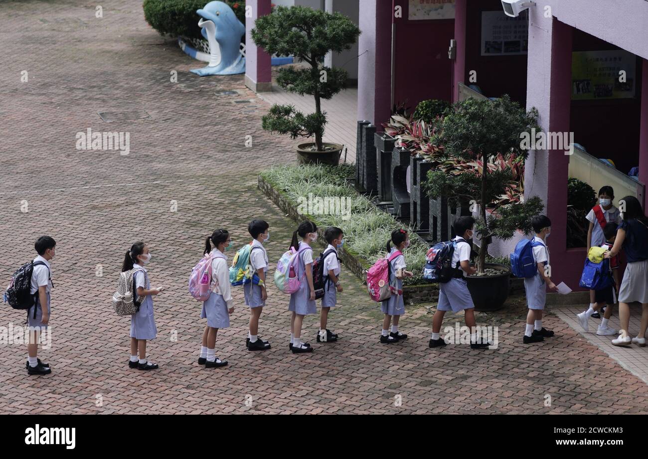 Hongkong, China. September 2020. Schüler stehen Schlange, um eine Grundschule in Hongkong, Südchina, zu betreten, 29. September 2020. Die Epidemie hat sich in Hongkong nach einer schnellen Reaktion auf die Epidemie und der starken Unterstützung durch die Zentralbehörden stark entspannt. Die sozialen Distanzierungsmaßnahmen wurden teilweise gelockert und das Leben der Menschen hat begonnen, sich wieder zu normalisieren. Alle Schüler kehrten am Dienstag in einer zweiphasigen Anordnung zu den Campus zurück, nachdem das persönliche Lernen vor etwa einer Woche für bestimmte Klassen verfügbar war. Quelle: Wang Shen/Xinhua/Alamy Live News Stockfoto