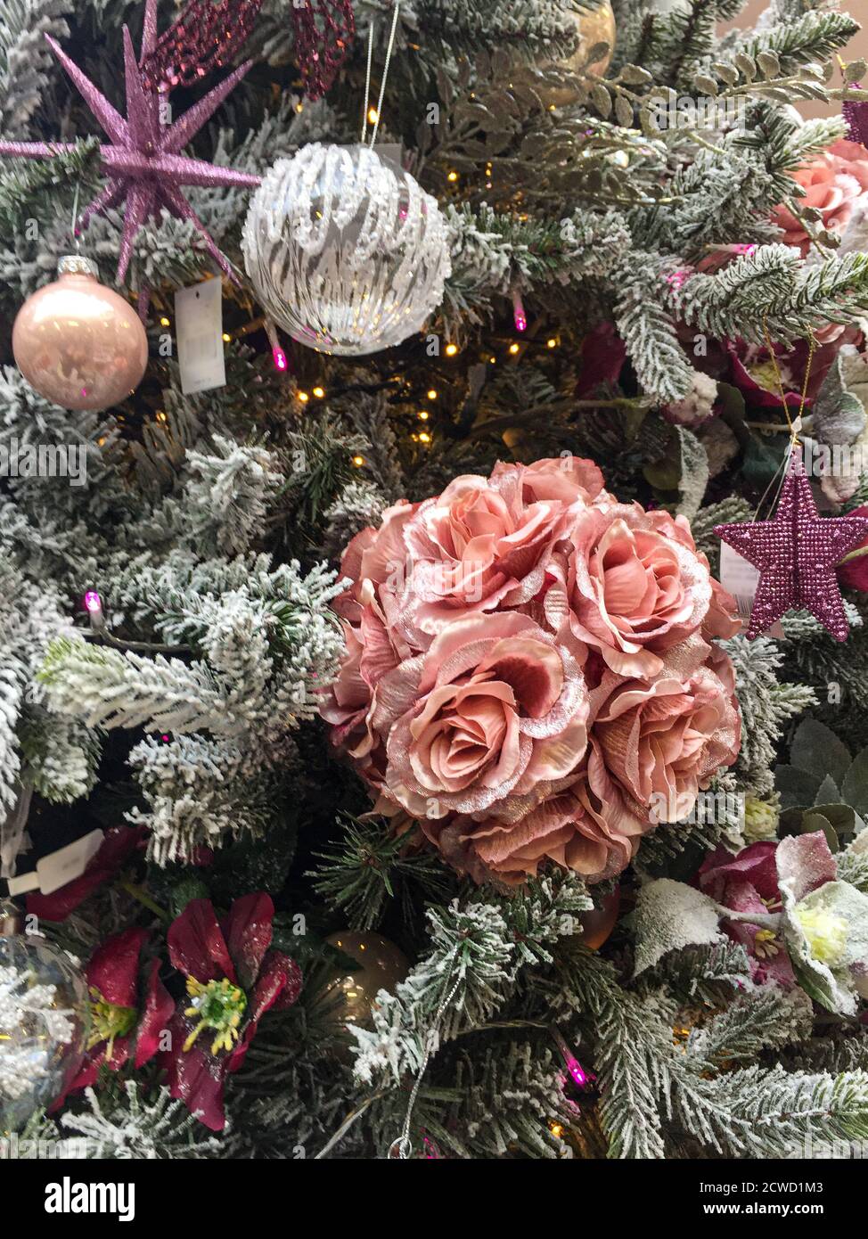 Dekorationen auf Weihnachtsbaum einschließlich rosa Rosen, Sterne und Kugeln. Stockfoto