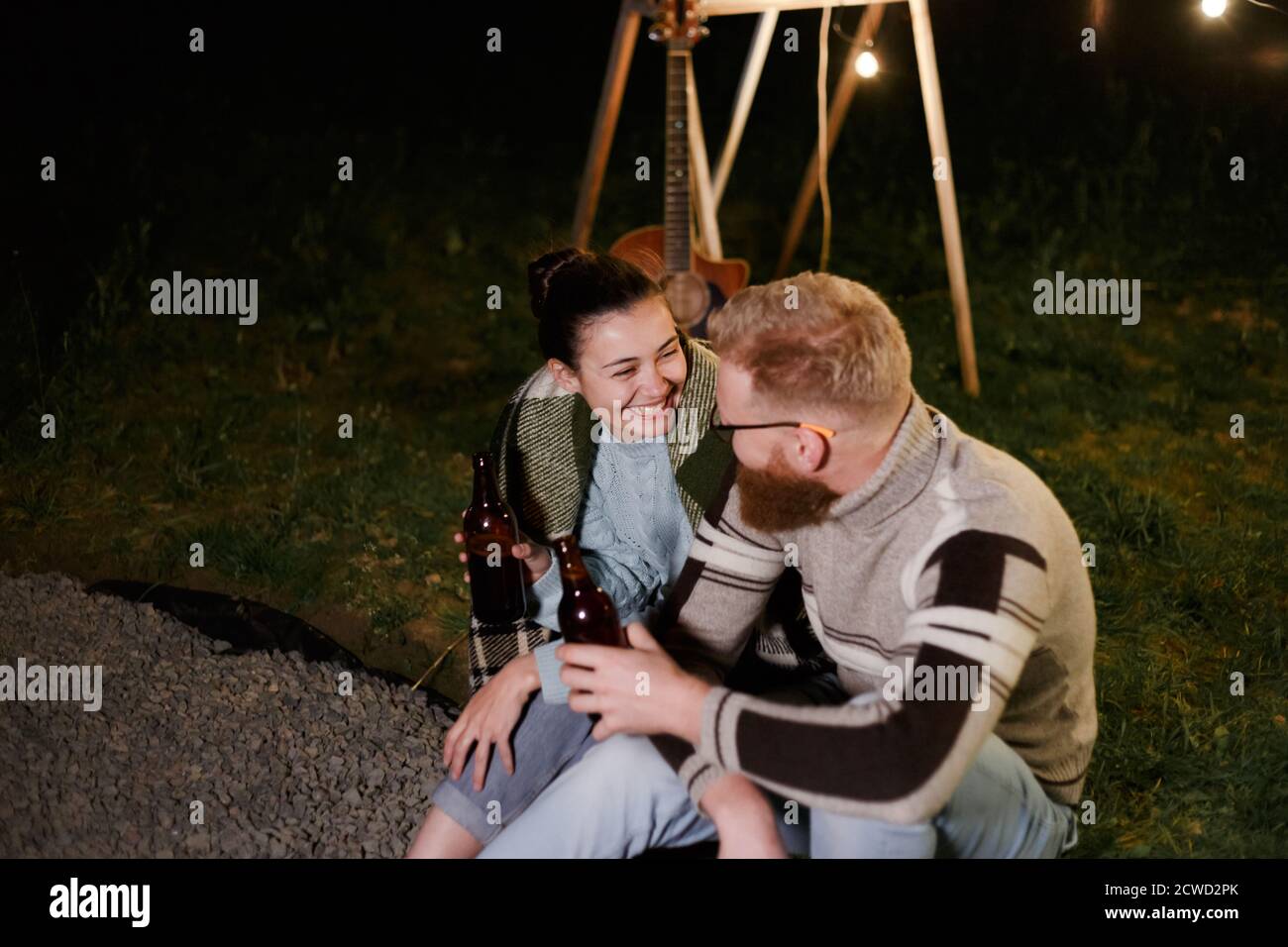 Pärchen haben eine gute Zeit zusammen am Abend Picknick trinken Getränke aus Flaschen Stockfoto