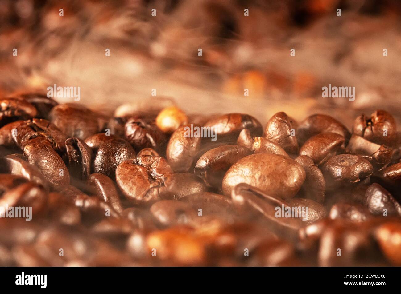 Frisch geröstete Kaffeebohnen mit Rauch. Stockfoto