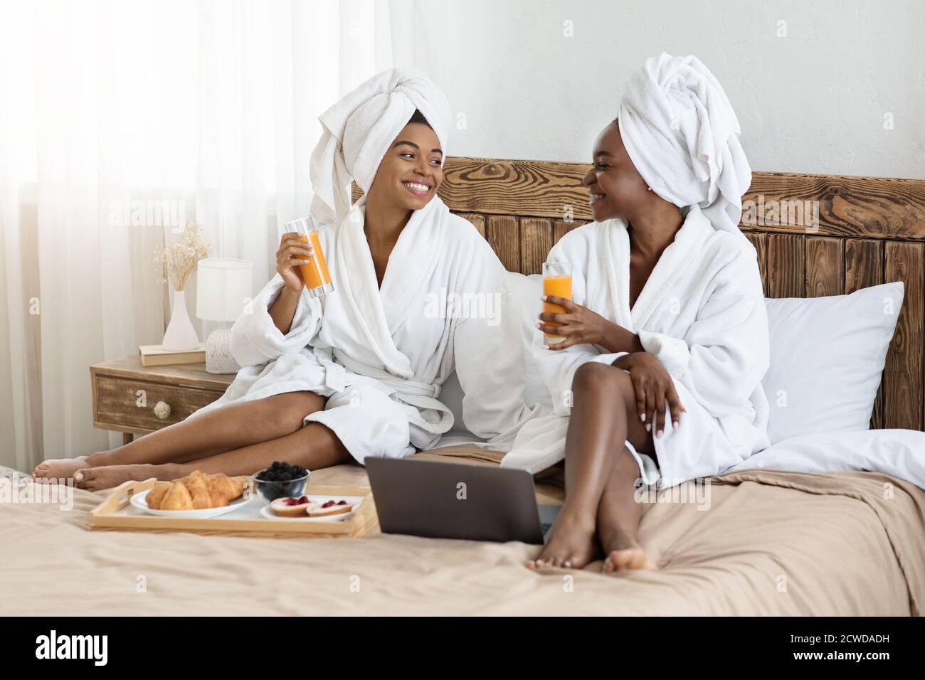 Zwei fröhliche schwarze Frauen beim Frühstück im Bett Stockfotografie -  Alamy