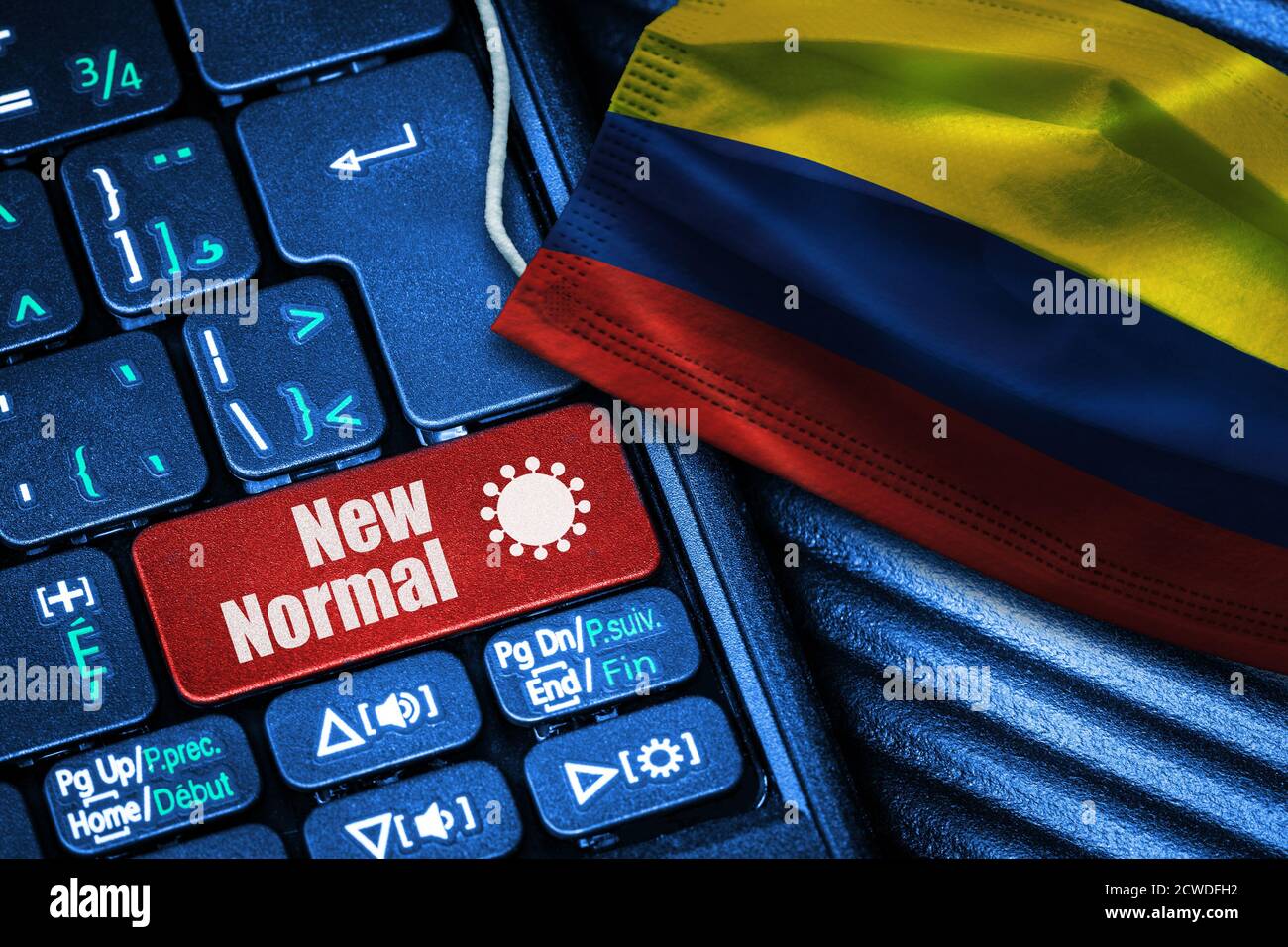 Konzept der New Normal in Kolumbien während Covid-19 mit Computer-Tastatur roten Button Text und Gesichtsmaske zeigt kolumbianische Flagge. Stockfoto