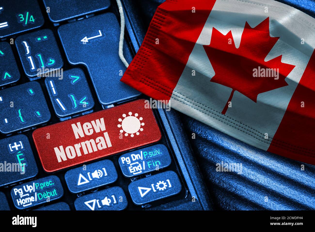 Konzept der New Normal in Kanada während Covid-19 mit Computer-Tastatur roten Button Text und Gesichtsmaske mit kanadischen Flagge. Stockfoto