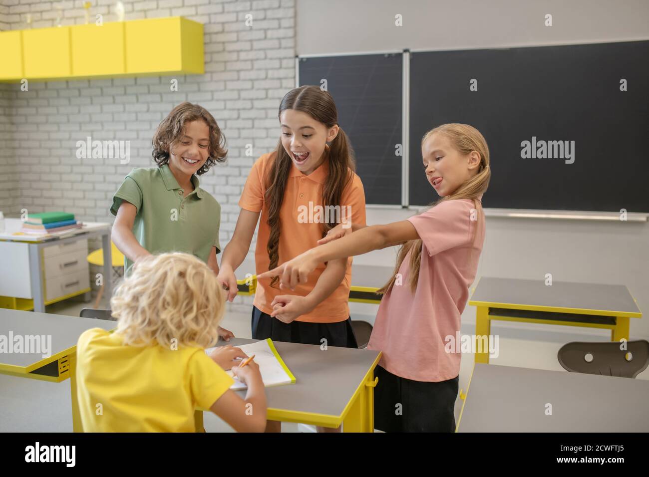 Blonde Jungen leiden unter Mobbing seiner Klassenkameraden Stockfoto