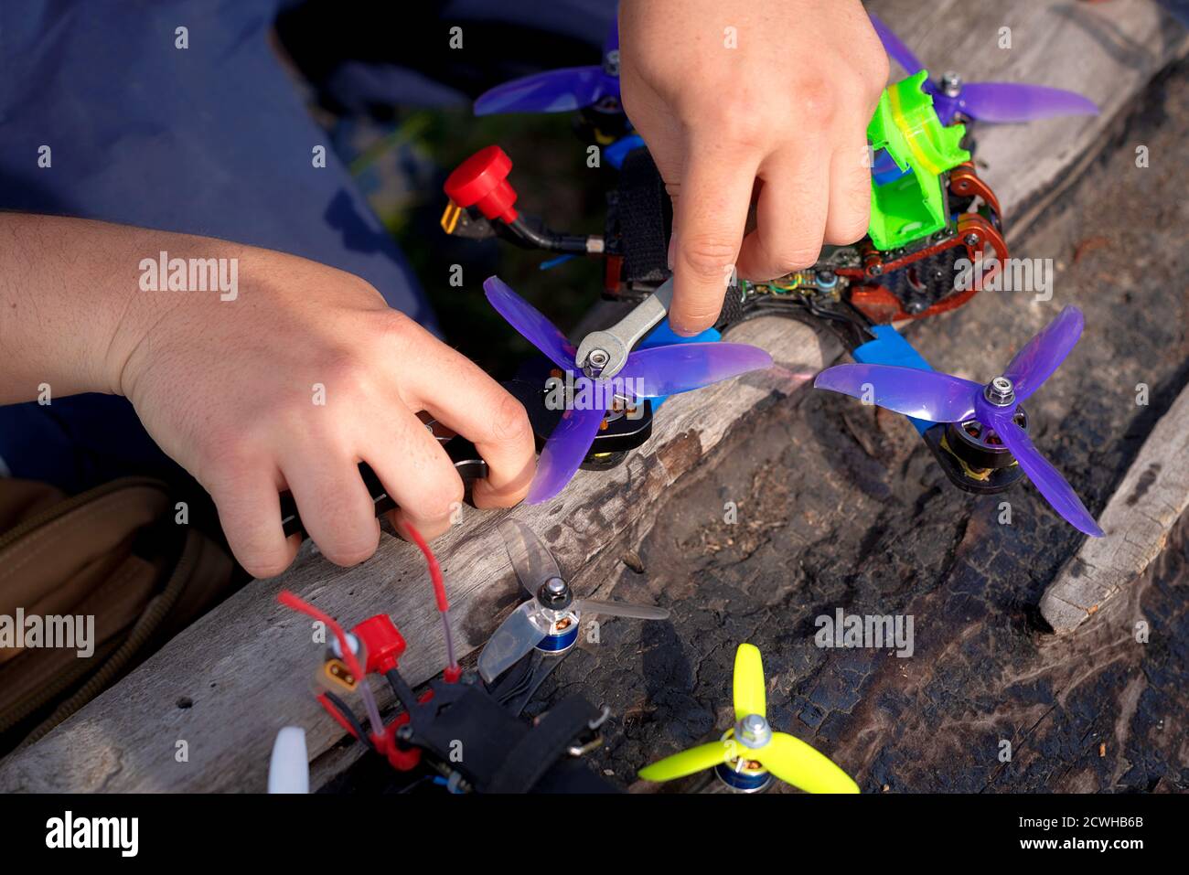 Mann repariert und justiert eine Renndrohne vor dem Fliegen Stockfoto