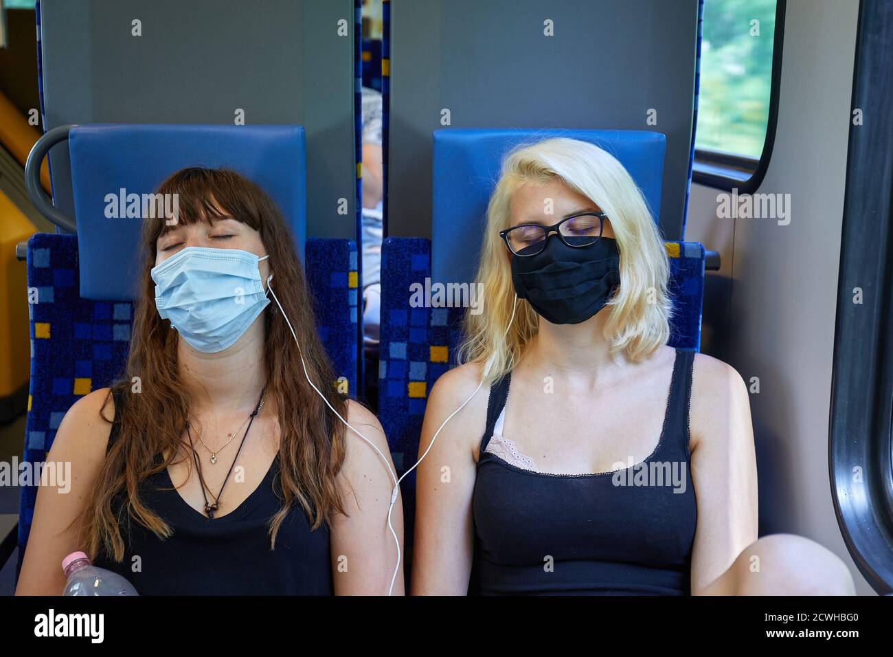 Junge Frauen in einem Zug mit Masken Stockfoto