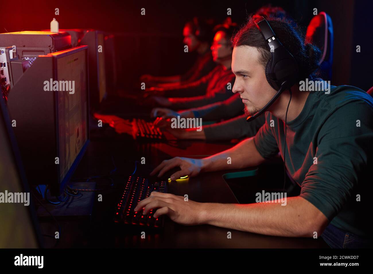 Junge Gamer in Kopfhörer Blick auf Computer-Monitor und spielen Spiele mit anderen Spielern im Computerclub Stockfoto