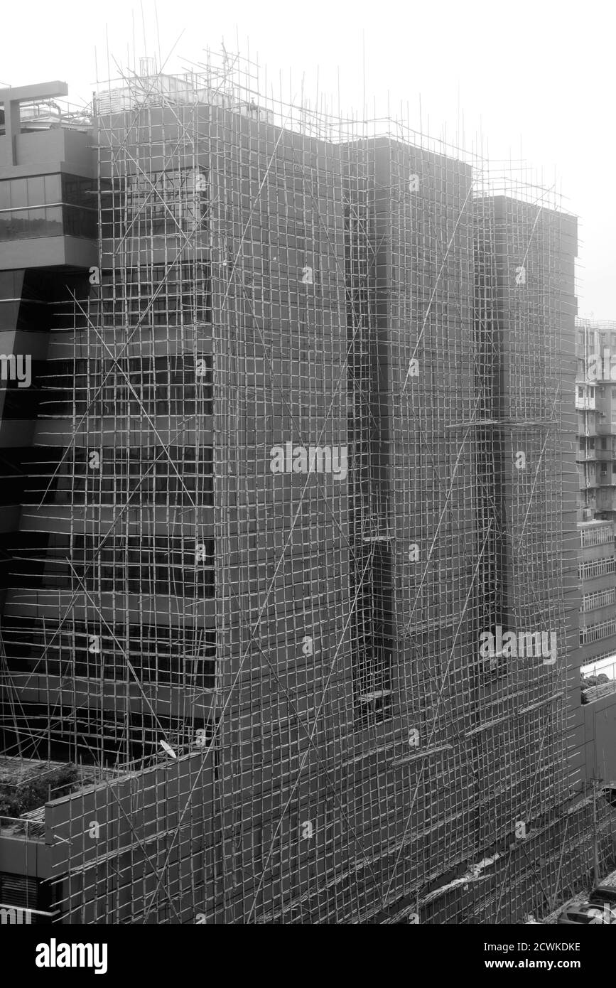 Die Außenwand des Gebäudes wird von Bambusgerüsten zur Renovierung bedeckt Arbeiten Stockfoto