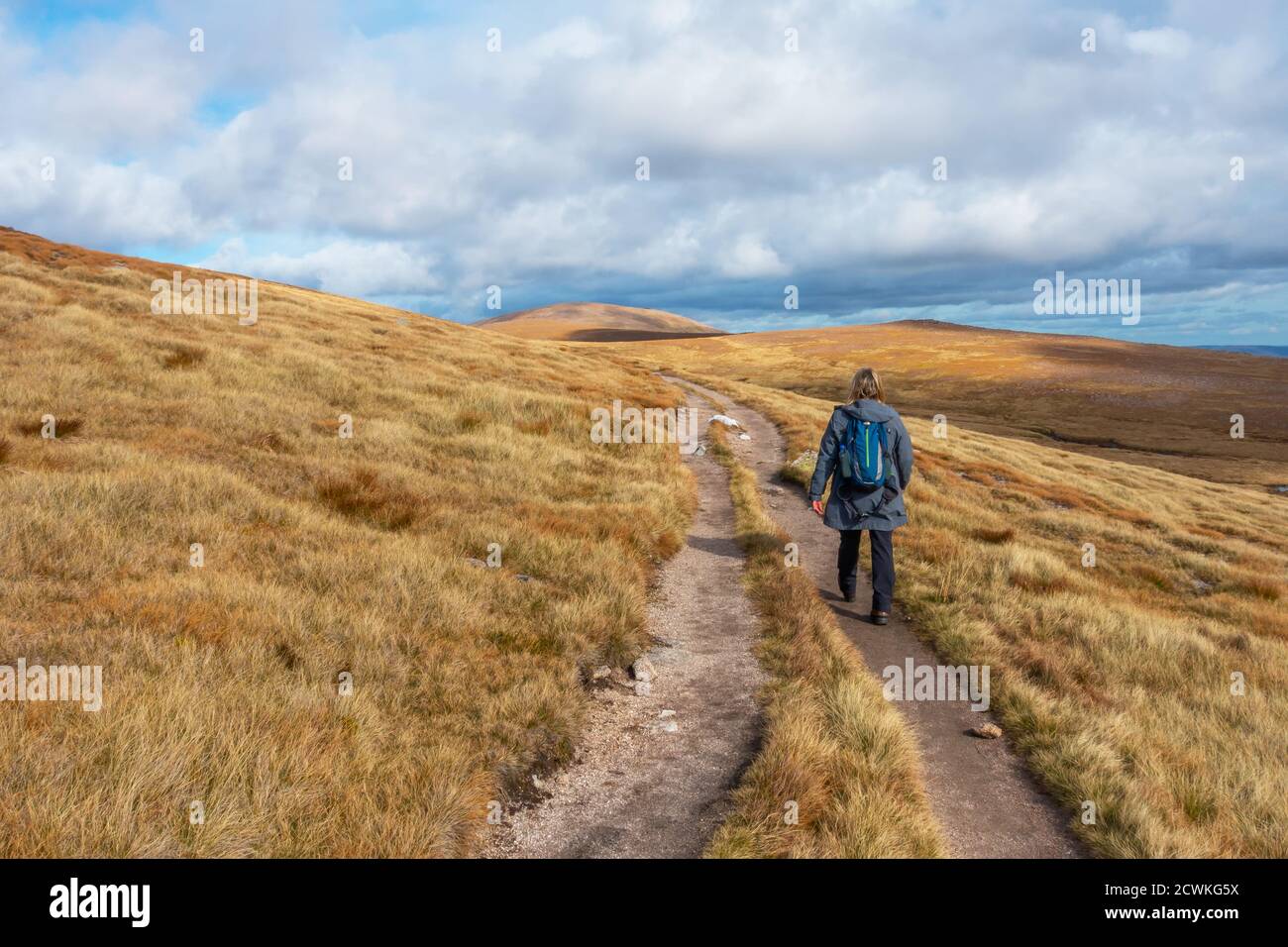 Walker auf dem Weg zum Berg Cairn Gorm (im Hintergrund gesehen), einem munro in der Nähe des Cairngorm Ski Centre in Aviemore, Schottland, Großbritannien Stockfoto