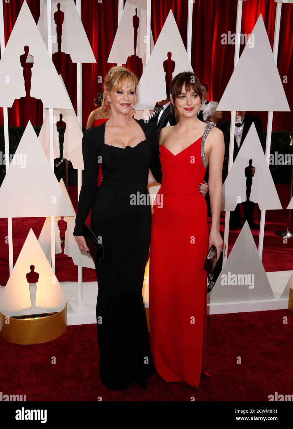 50 Shades of Grey" Schauspielerin Dakota Johnson trägt eine rote Saint  Laurent-Kleid mit hohem Schlitz und Forevermark Diamanten mit ihrer Mutter  Melanie Griffith (L) bei der 87. Oscarverleihung in Hollywood, Kalifornien  22.