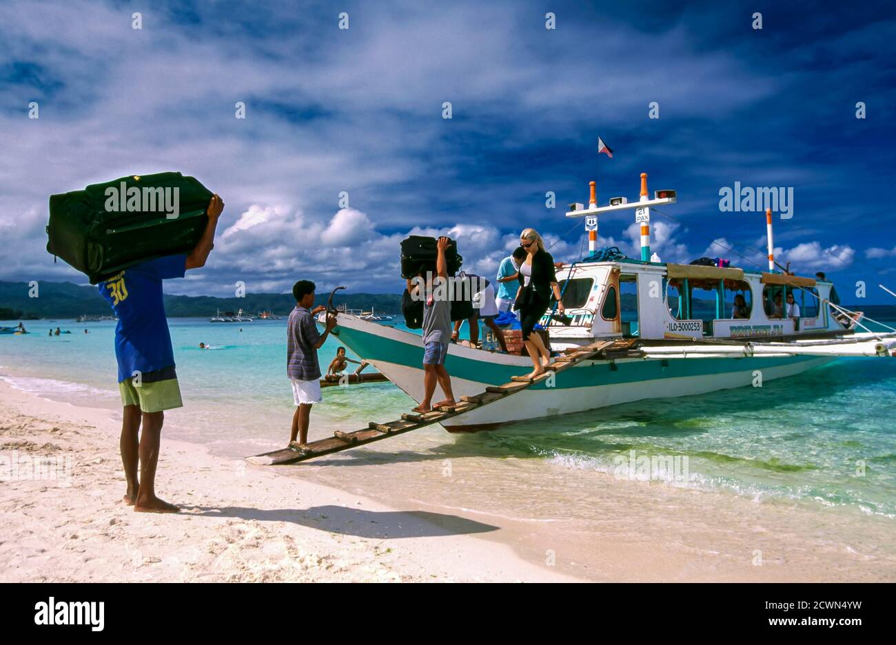 Touristen und Gepäck Ankunft mit dem Boot in White Beach, Boracay, Philippinen Stockfoto