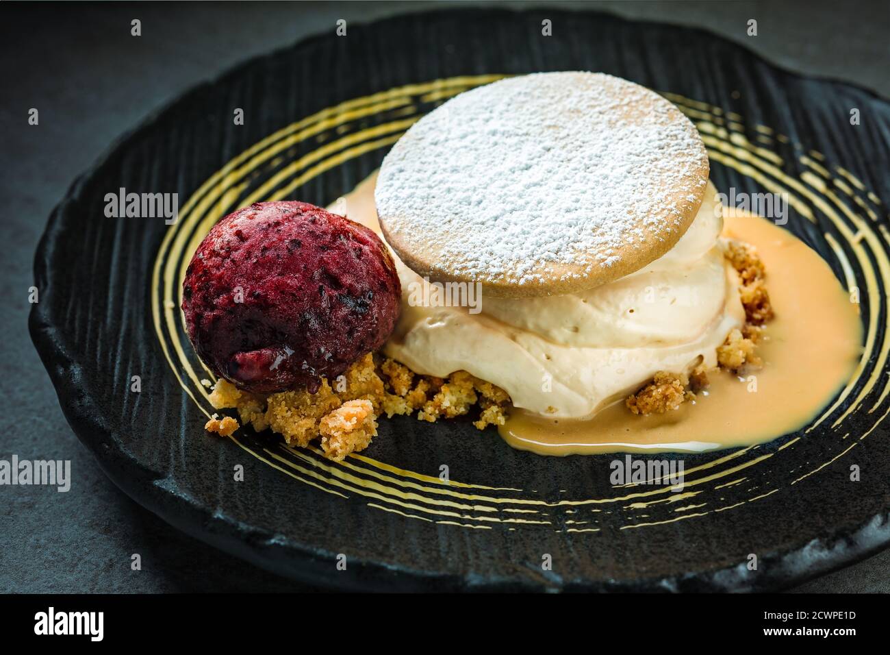 Dekadente offene Plätzchen mit Karamellmousse und Heidelbeer-Eis Stockfoto