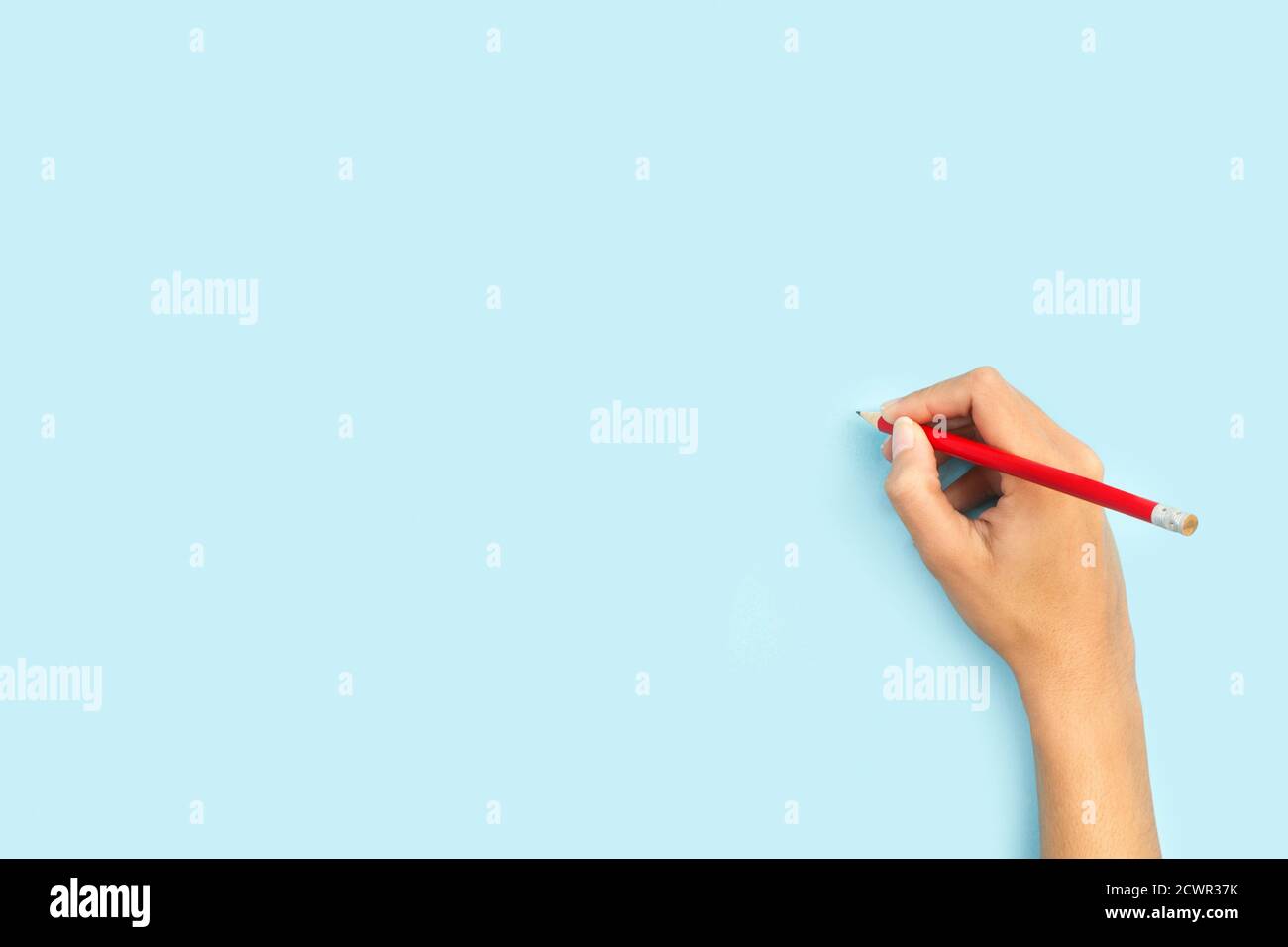 Frau mit einem Bleistift auf einem hellblauen Hintergrund mit Speicherplatz kopieren Stockfoto