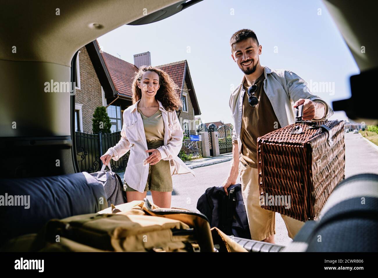 Über dem Kofferraum Blick auf fröhliche energische junge Paar Putting Wandern Während Sie sich auf ein aufregendes Abenteuer vorbereiten Stockfoto