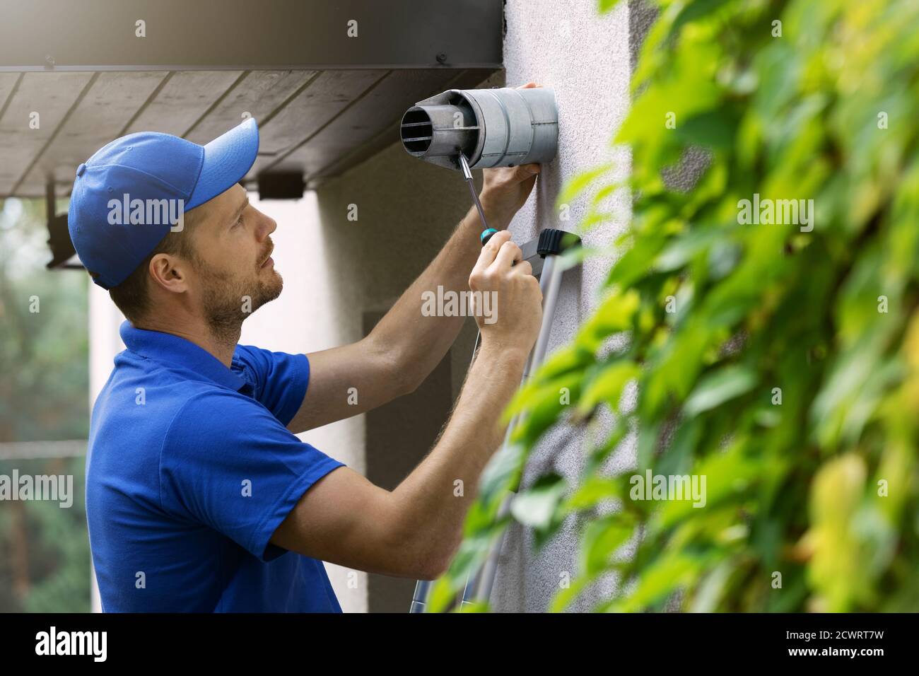 hlk-Servicemitarbeiter, die Wartung und Reparatur von Zentralgas durchführen Heizkessel Rauchkamin auf Haus außen Stockfoto