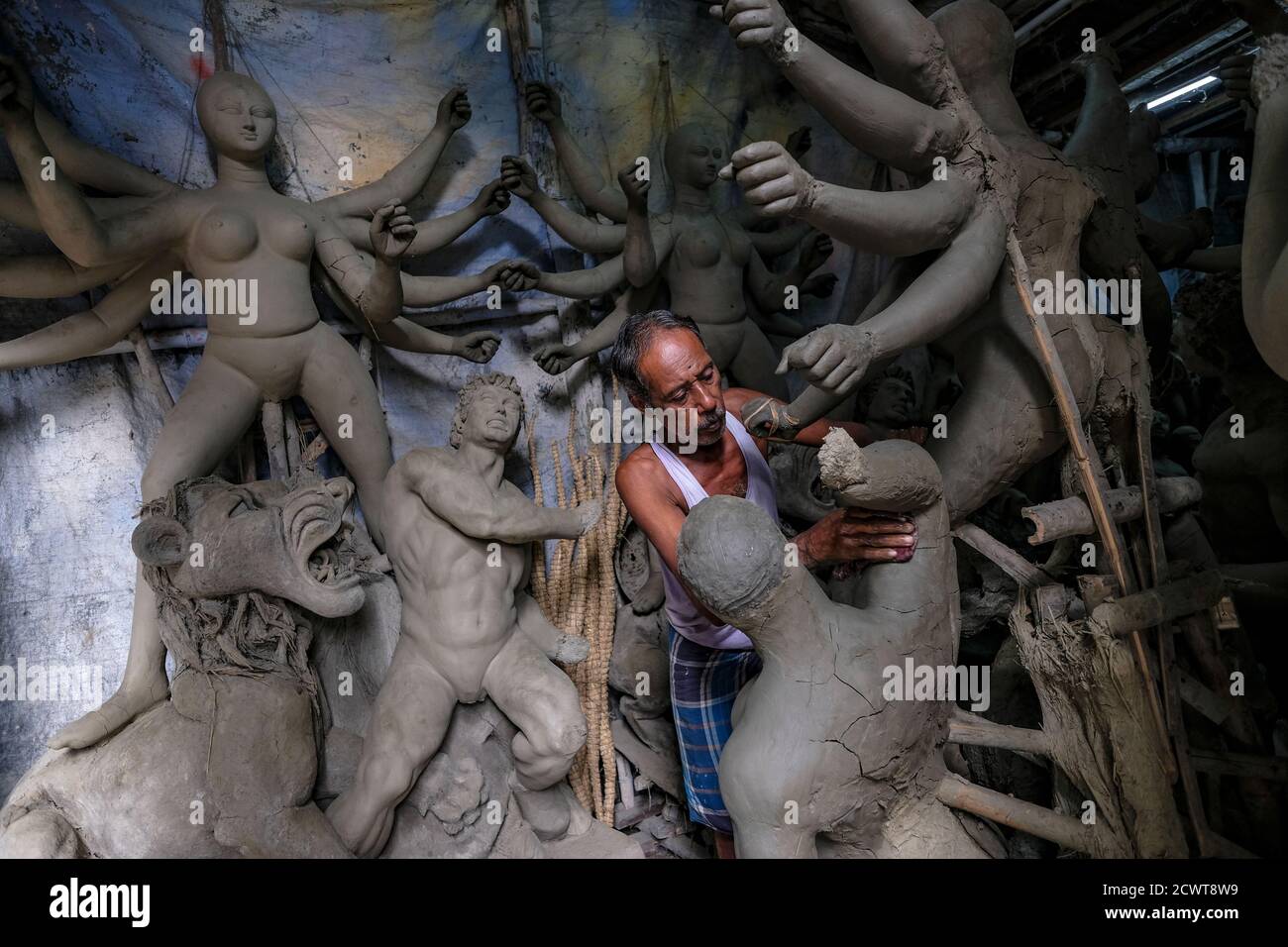 Kolkata, Indien - September 2020: Ein Handwerker, der Lehm- und Strohskulpturen für das Durga Puja Festival in Kumartuli, Kolkata, macht. Indien. Stockfoto