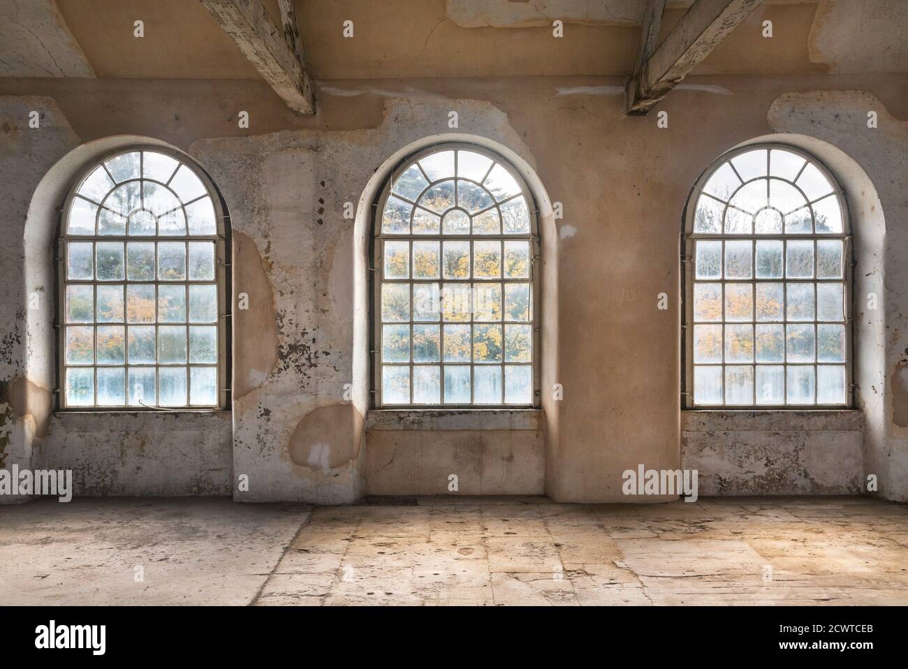 Drei Bogenfenster in einer stillgewebeenden Textilfabrik Stockfoto