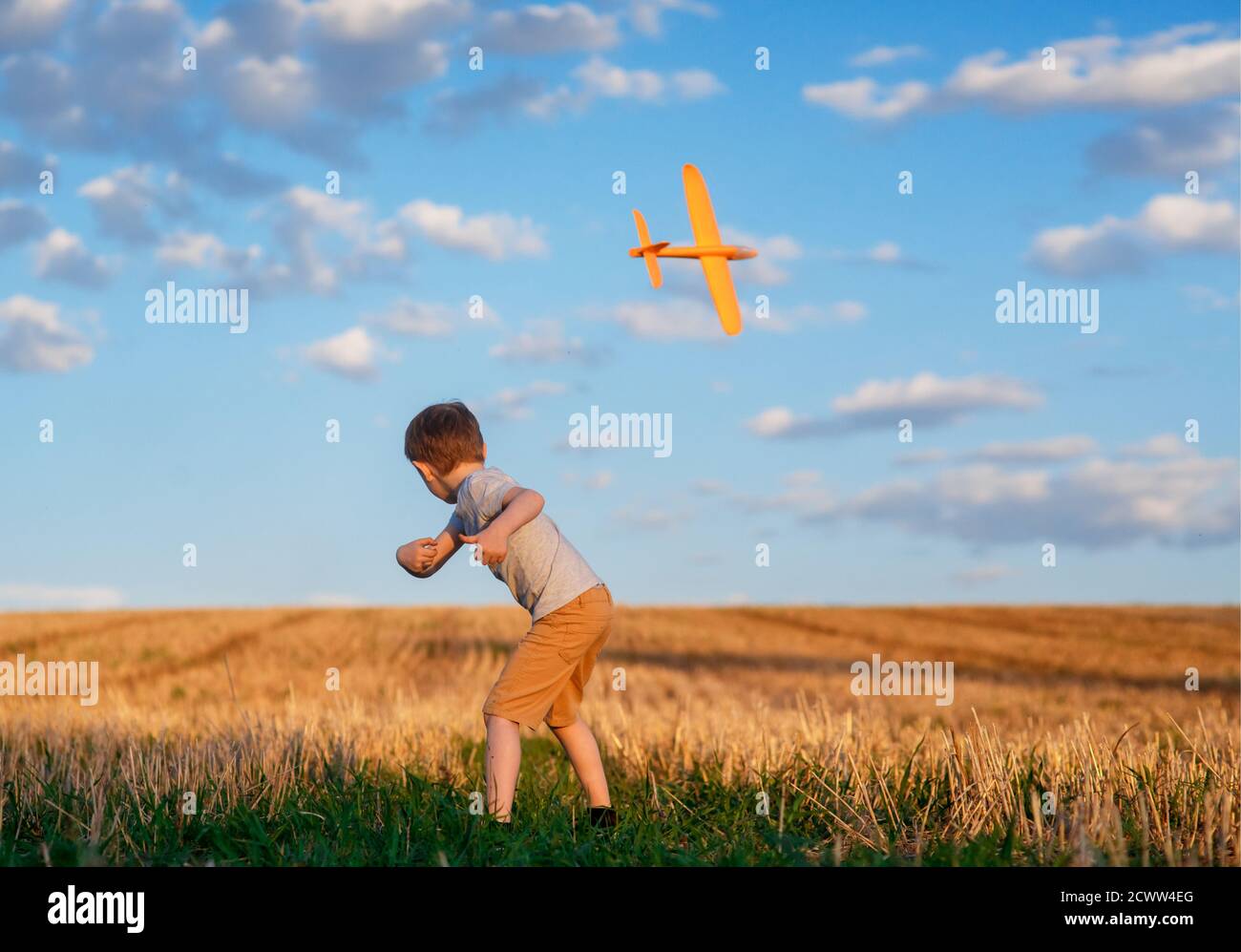 Happy Kind läuft mit Spielzeug Flugzeug auf Himmel Hintergrund glücklich Familie Konzept. Kindheitstraum Stockfoto