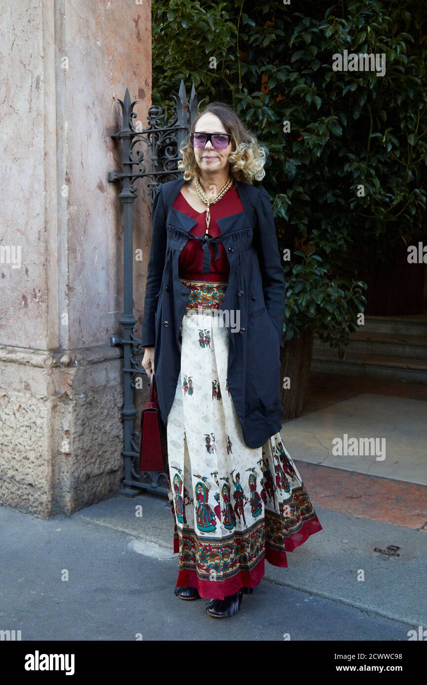 MAILAND, ITALIEN - 27. SEPTEMBER 2020: Frau mit schwarzem Mantel und rot-weißen Kleid vor SHI.RT Modenschau, Mailand Fashion Week Street style Stockfoto