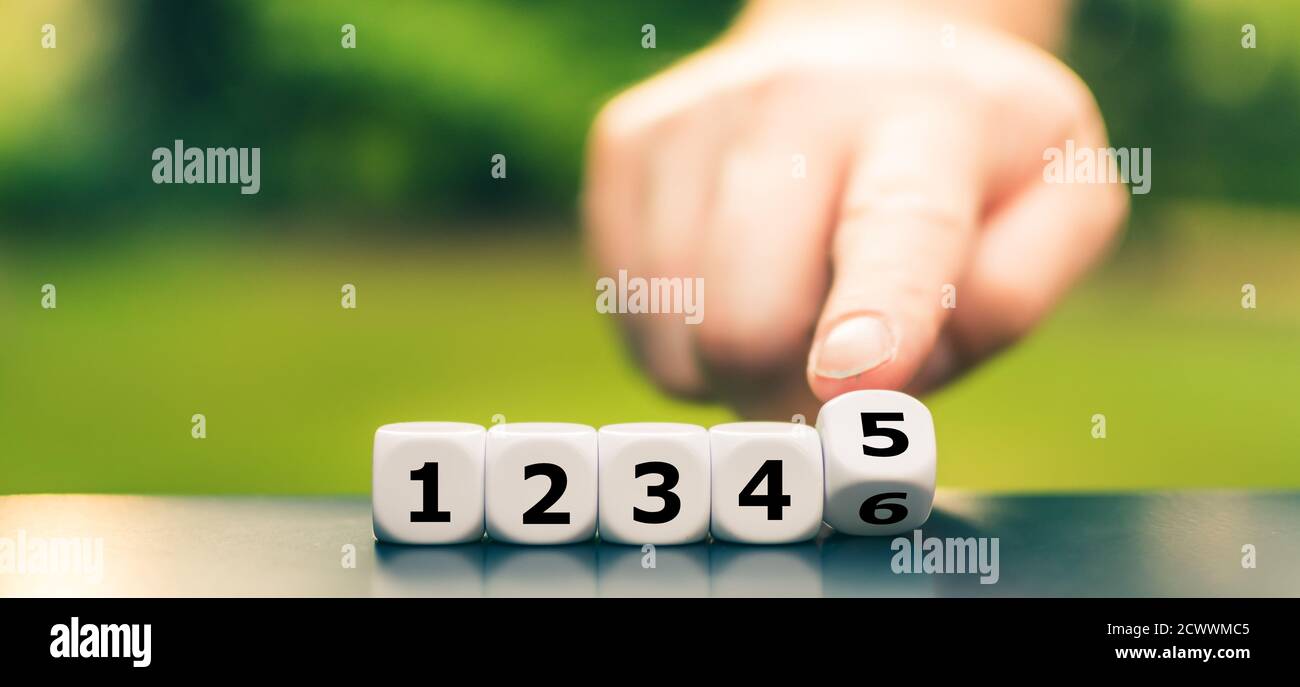Symbol für Grundunterricht. Die Hand dreht Würfel und korrigiert die Zahlenfolge von '1 2 3 4 6' auf '1 2 3 4 5'. Stockfoto