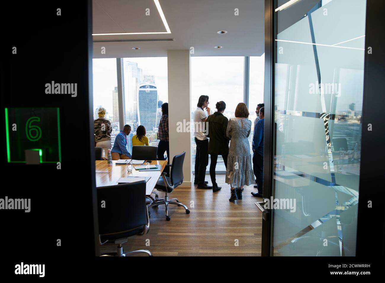 Geschäftsleute, die sich im Hochhaus-Konferenzraum unterhalten Stockfoto