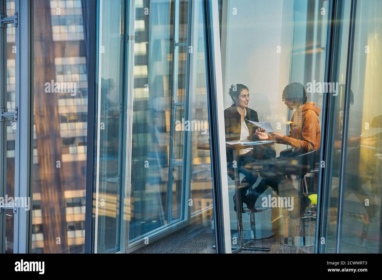 Geschäftsleute treffen sich am Bürofenster im Hochhaus Stockfoto