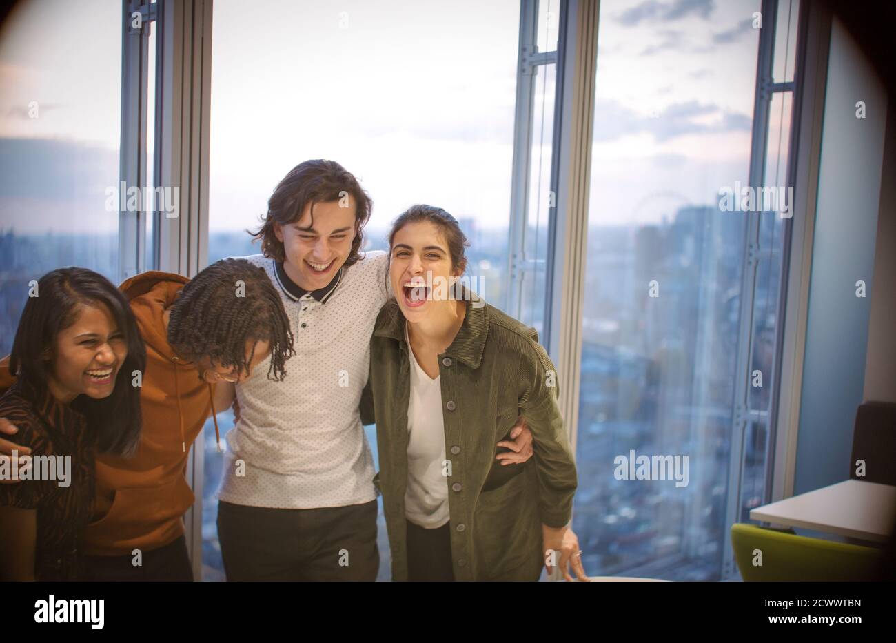 Glückliche junge Geschäftsleute, die im Hochhaus lachen Stockfoto