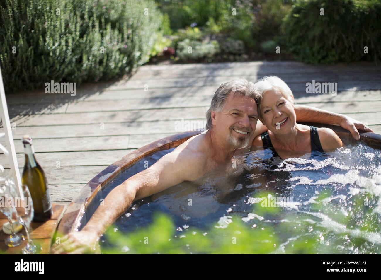 Portrait glücklich Senior paar entspannen im Whirlpool auf sonnig Terrasse Stockfoto