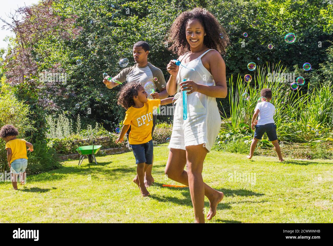 Glückliche Familie spielen und Blasen in sonnigen Sommergarten Stockfoto