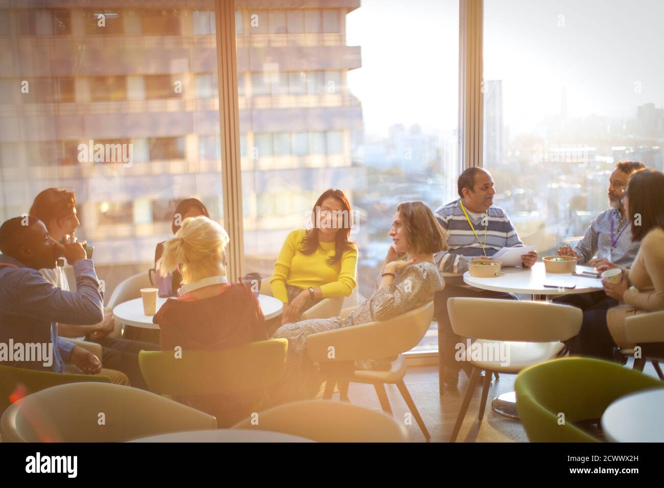 Geschäftsleute unterhalten sich und essen Mittagessen in der Cafeteria im Hochhaus Stockfoto