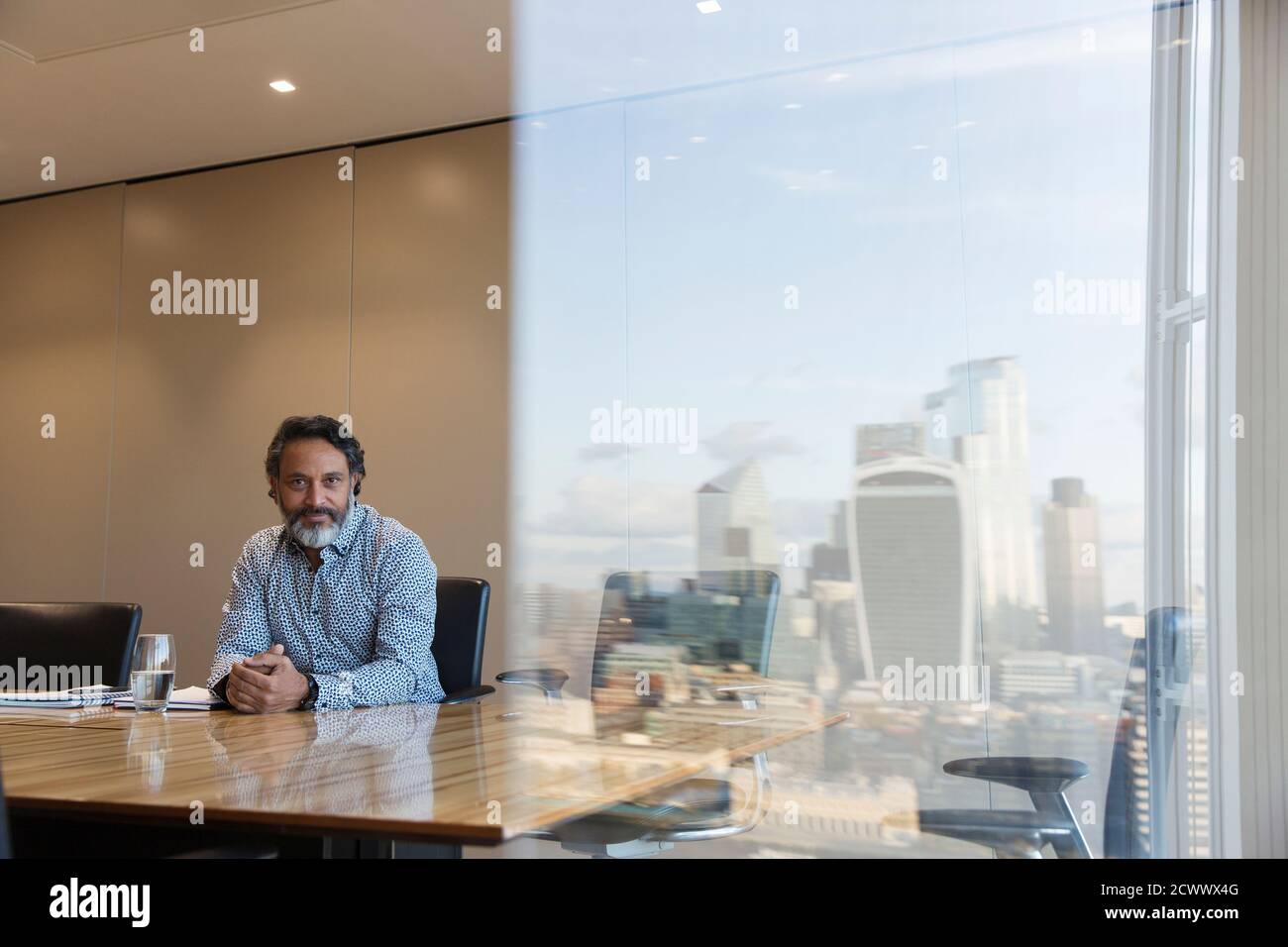 Portrait selbstbewusster Geschäftsmann im Hochhaus-Konferenzraum, London, Großbritannien Stockfoto