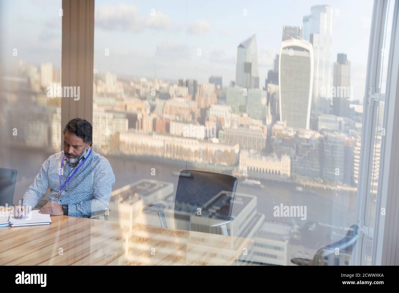 Geschäftsmann, der im städtischen Hochhaus-Konferenzraum, London, Großbritannien, arbeitet Stockfoto