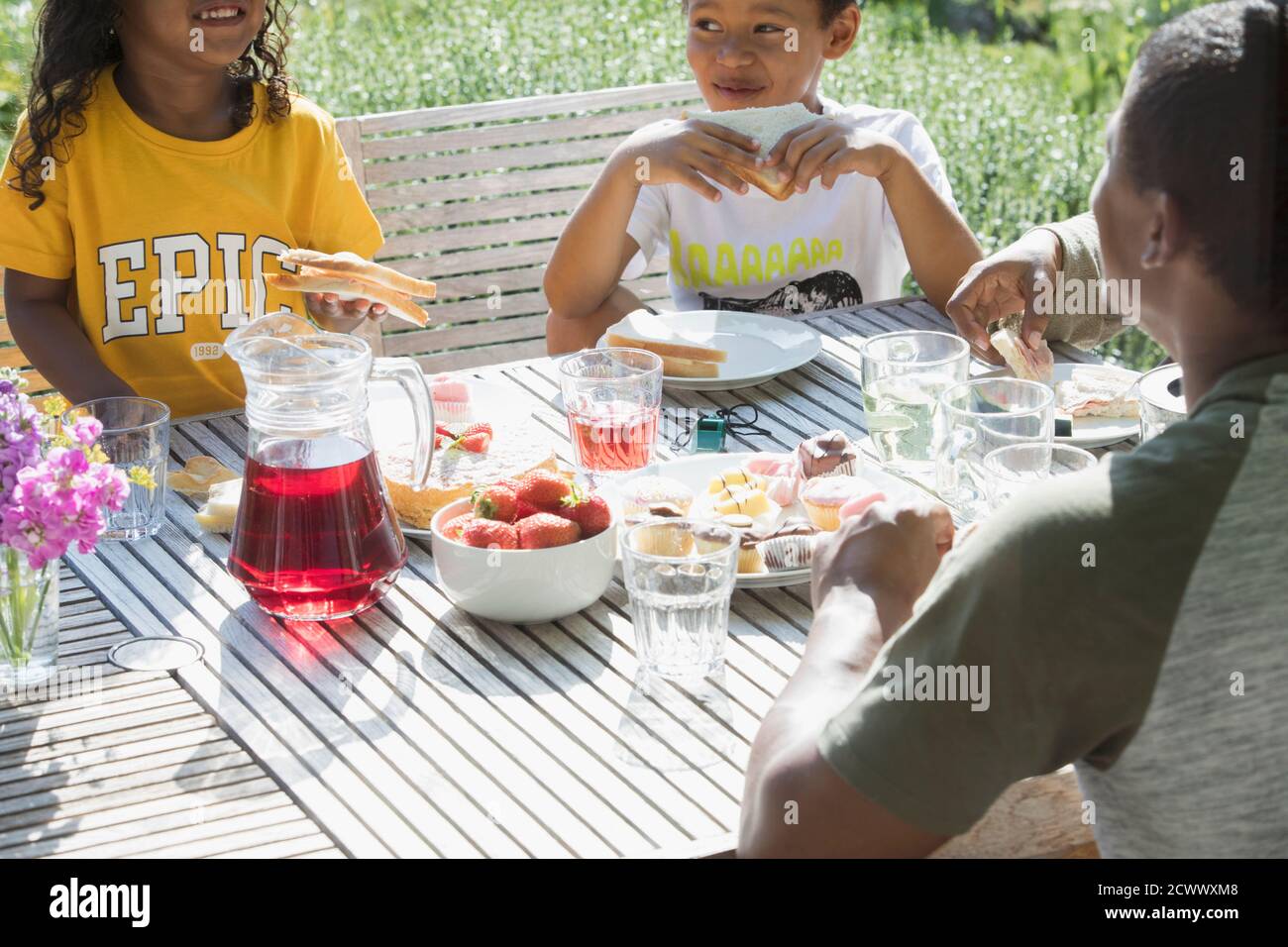Familie essen Mittagessen an sonnigen Sommer Terrasse Tisch Stockfoto