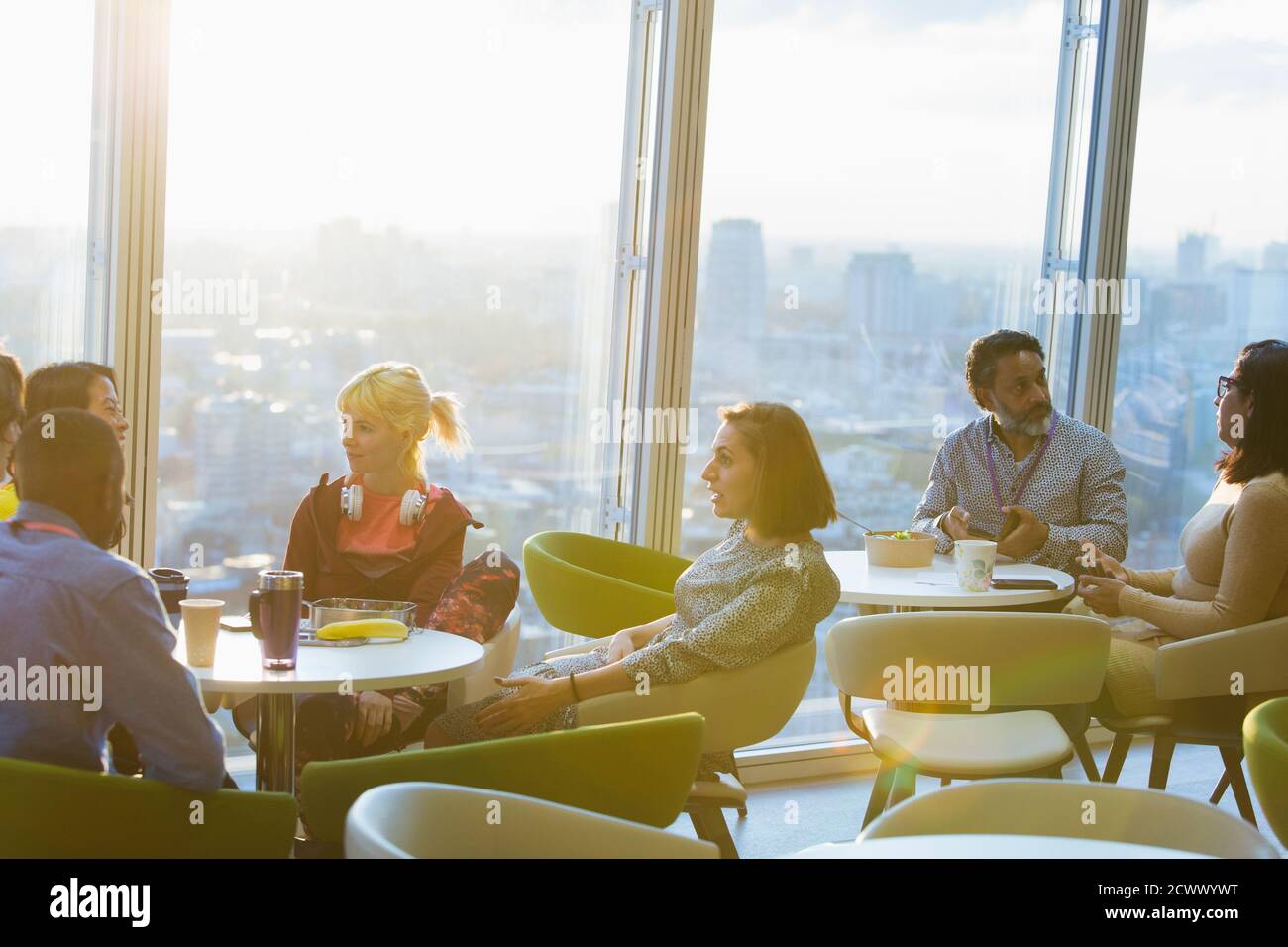 Geschäftsleute treffen sich in der sonnigen Bürokantine im Hochhaus Stockfoto